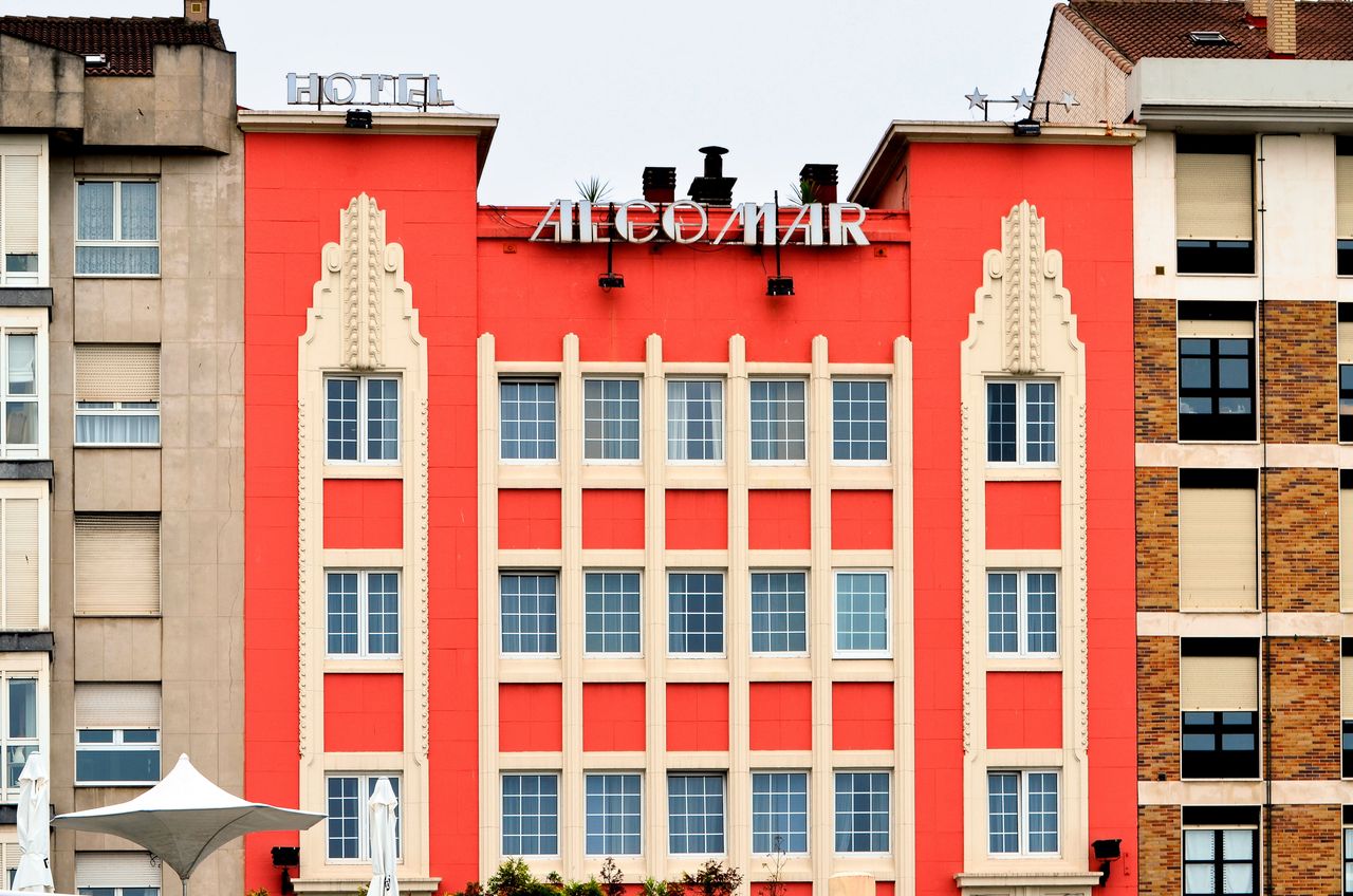 Home Art Deco facade of Hotel Alcomar in Gijón, showcasing vibrant architectural design.
